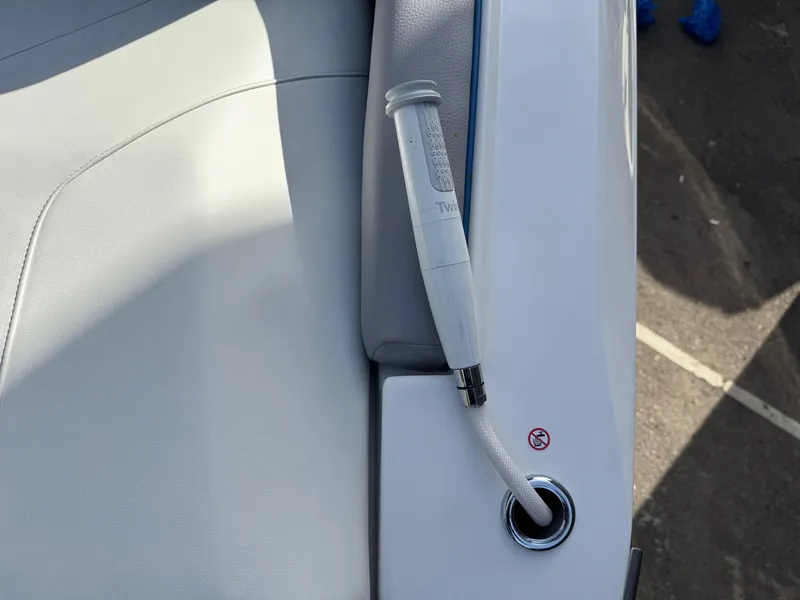 Slide: The Image of 2025 Regal LS9 Surf boat interior with white upholstery and a retractable shower hose. - 42