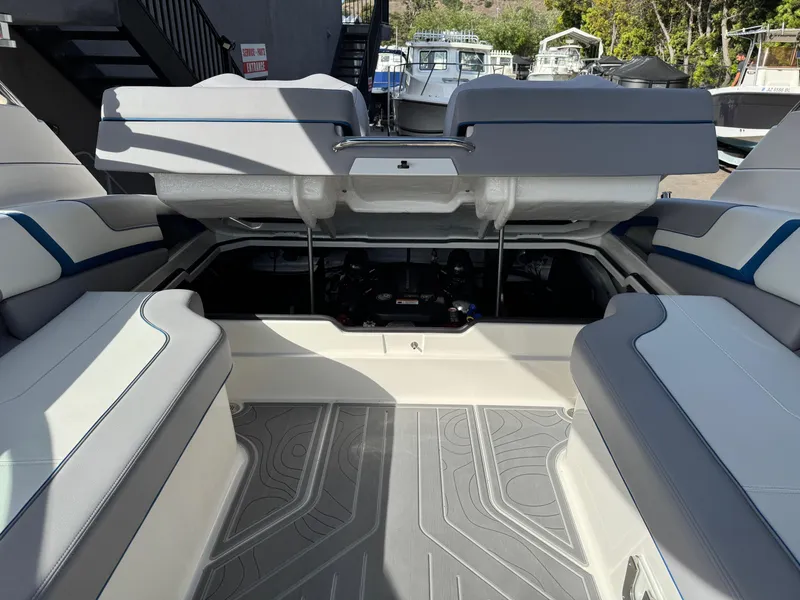 Slide: The Image of 2025 Regal LS9 Surf boat interior with open engine compartment, showcasing seating and deck design. - 50