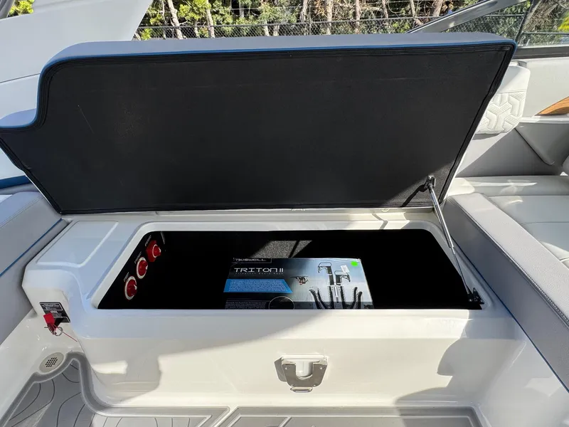Slide: The Image of 2025 Regal LS9 Surf boat storage compartment with open lid, showcasing interior space. - 57