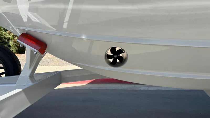 Slide: The Image of 2025 Regal LS9 Surf boat on trailer, sleek design, triple-axle, parked outdoors. - 6