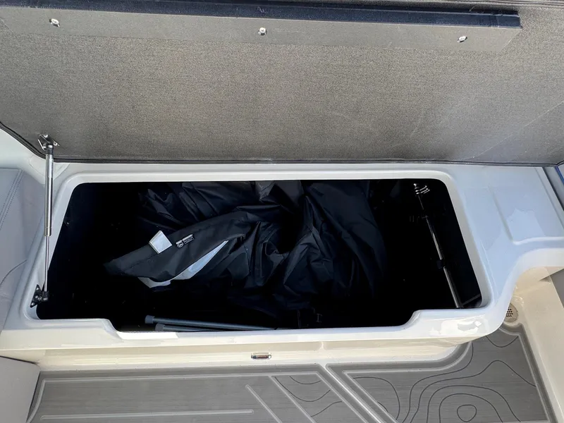 Slide: The Image of Open storage compartment in 2025 Regal LS9 Surf boat, showing interior space. - 63