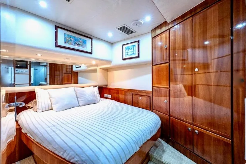 Slide: The Image of Luxurious cabin interior of 2001 Bertram 510 Convertible yacht with wood paneling and cozy bed. - 19