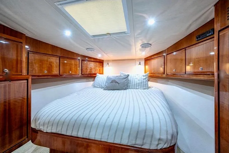 Slide: The Image of Luxurious cabin interior of 2001 Bertram 510 Convertible yacht with wood paneling and cozy bed. - 21
