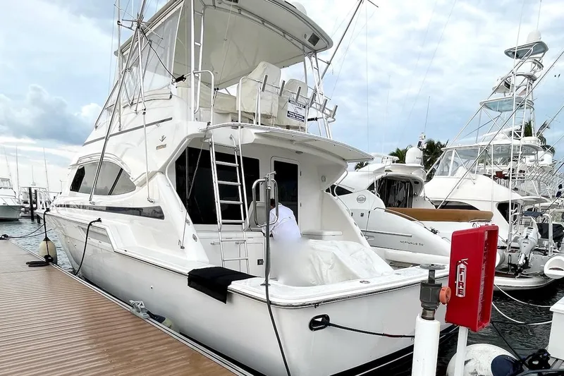 Slide: The Image of 2001 Bertram 510 Convertible yacht docked at marina, featuring sleek design and spacious deck. - 28