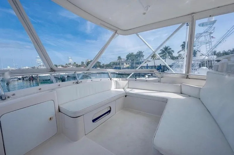 Slide: The Image of 2001 Bertram 510 Convertible yacht interior with white seating and marina view. - 36
