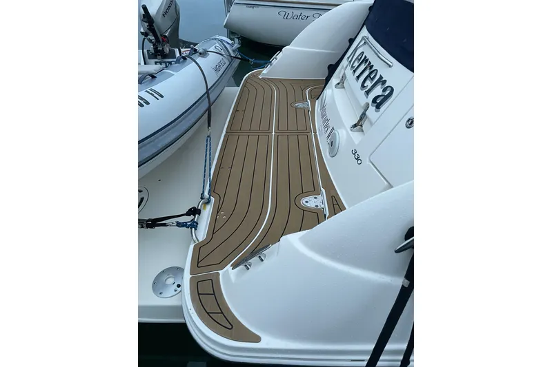 Slide: The Image of 2008 Sea Ray 330 Sundancer boat with teak deck and visible branding. - 10