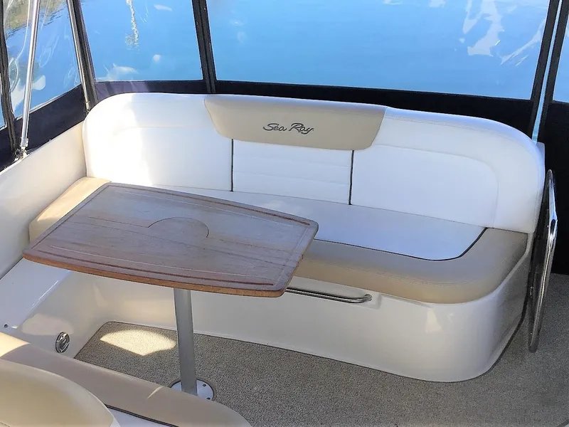 Slide: The Image of 2008 Sea Ray 330 Sundancer interior with cushioned seating and wooden table. - 13