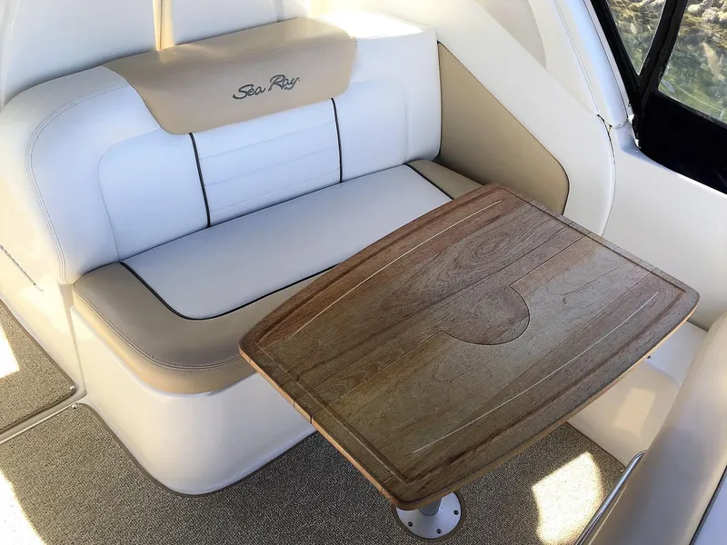 Slide: The Image of 2008 Sea Ray 330 Sundancer interior with cushioned seating and wooden table. - 15