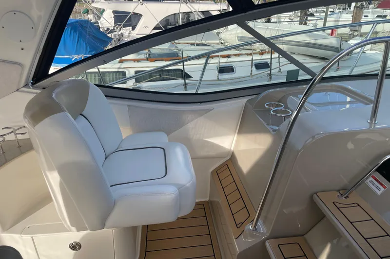 Slide: The Image of 2008 Sea Ray 330 Sundancer cockpit with white seating and wood accents, docked at marina. - 17