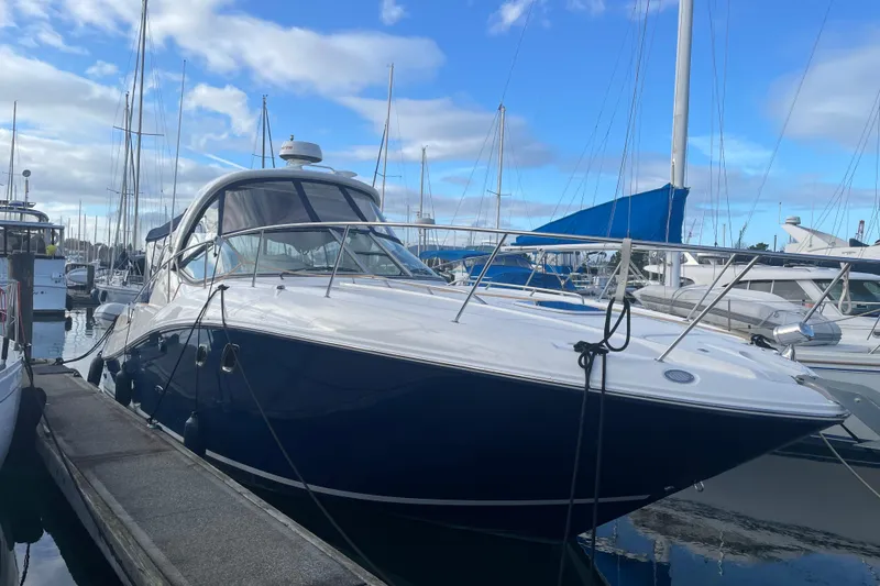 Slide: The Image of 2008 Sea Ray 330 Sundancer yacht docked at marina under blue sky. - 2