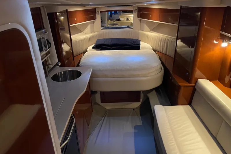 Slide: The Image of 2008 Sea Ray 330 Sundancer cabin interior with bed, kitchenette, and seating area. - 29
