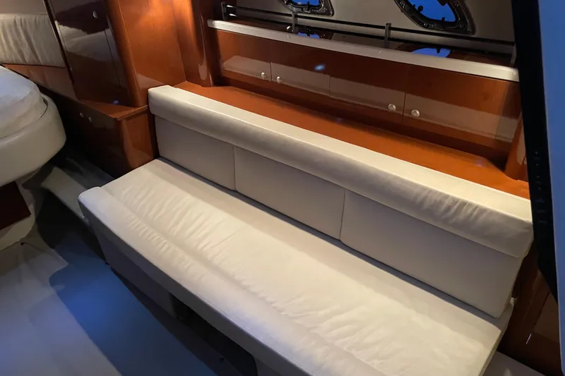 Slide: The Image of Interior of 2008 Sea Ray 330 Sundancer with white leather seating and wooden cabinetry. - 32
