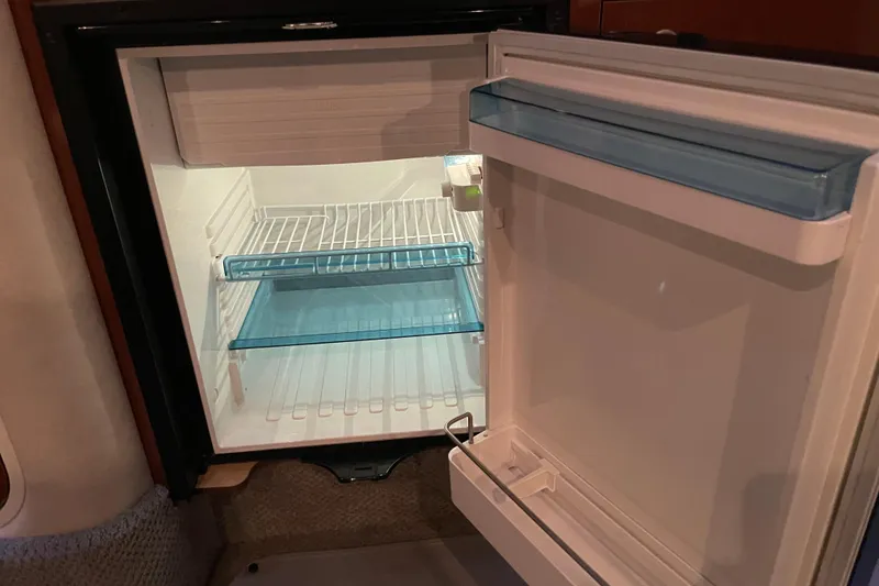 Slide: The Image of Open refrigerator inside 2008 Sea Ray 330 Sundancer boat, showing empty shelves. - 37