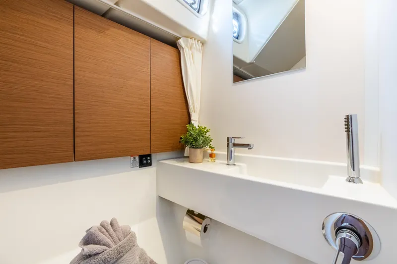 Slide: The Image of Modern bathroom in 2021 Beneteau Oceanis Yacht 54, featuring sleek sink and wooden cabinetry. - 56