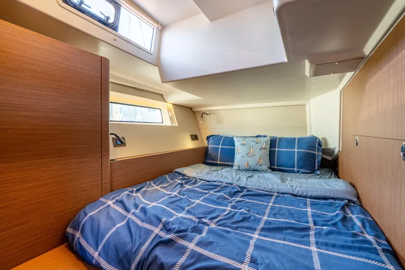 Slide: The Image of Cozy cabin interior of 2021 Beneteau Oceanis Yacht 54 with nautical-themed bedding. - 61