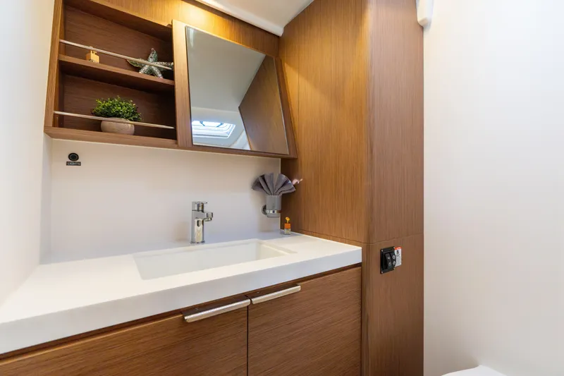 Slide: The Image of Modern bathroom interior on 2021 Beneteau Oceanis Yacht 54, featuring sleek wood cabinetry. - 75