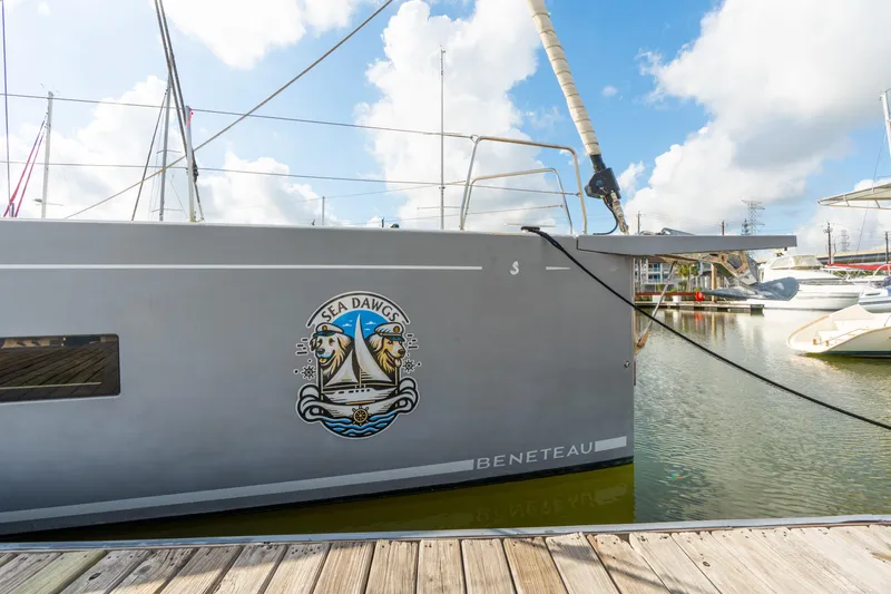 Slide: The Image of Beneteau Oceanis Yacht 54, 2021 model, docked with "Sea Dawgs" emblem. - 80