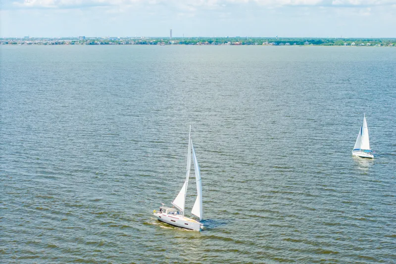 Slide: The Image of Sailboats on open water, featuring a 2021 Beneteau Oceanis Yacht 54. - 87