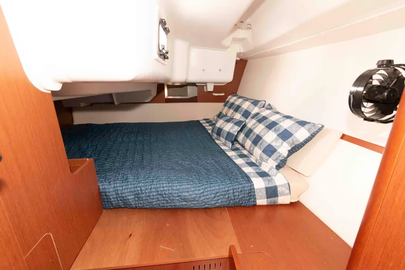 Slide: The Image of Cozy cabin interior of 2015 Beneteau Oceanis 37 with blue bedding and wood finish. - 14