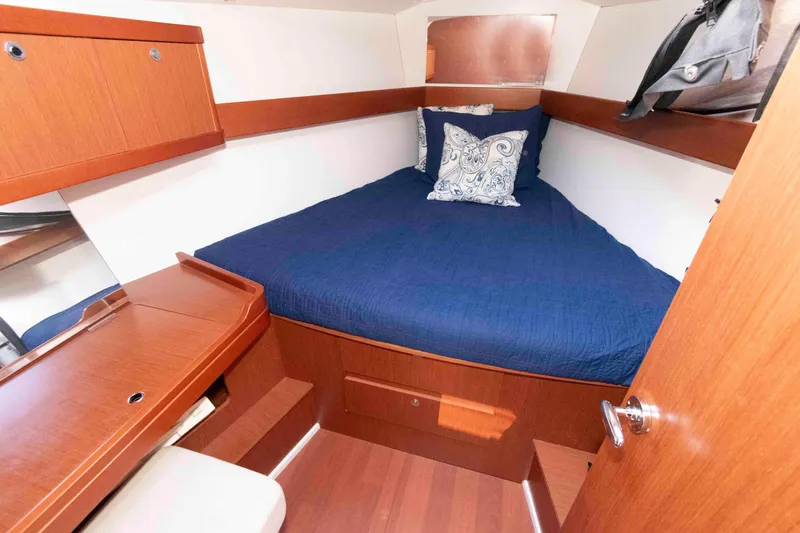 Slide: The Image of Cozy cabin interior of 2015 Beneteau Oceanis 37 with blue bedding and wooden furnishings. - 15