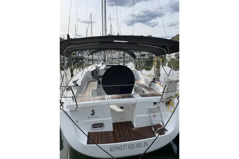 Slide: The Image of 2015 Beneteau Oceanis 37 sailboat docked in a marina, surrounded by other boats. - 2