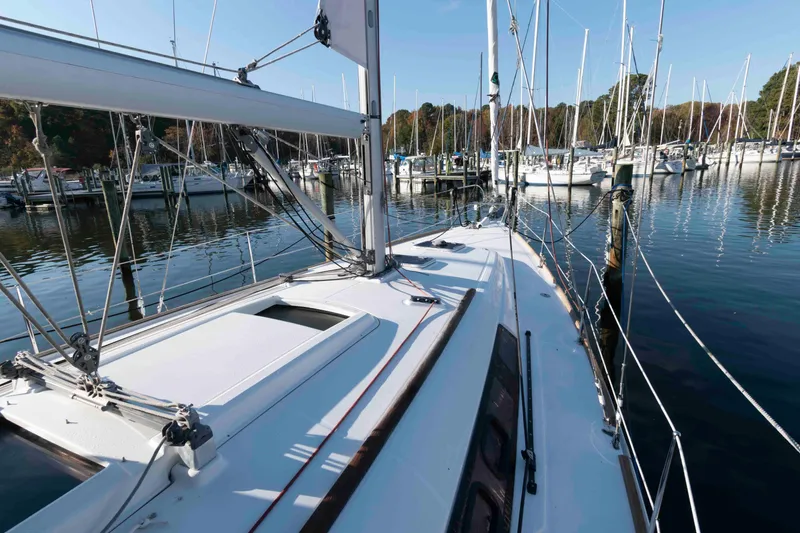 Slide: The Image of 2015 Beneteau Oceanis 37 sailboat docked in a marina, surrounded by calm waters. - 7