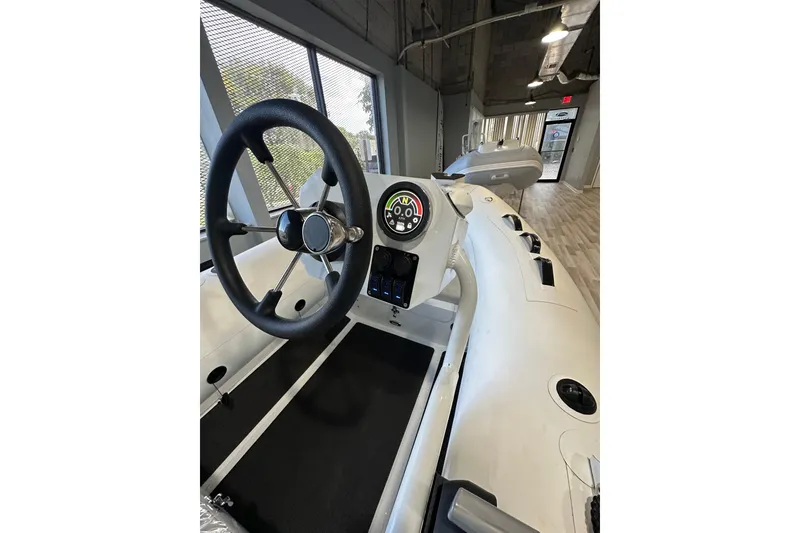 Slide: The Image of 2026 East Marine 320 Electric Tohatsu Alaris boat interior with steering wheel and controls. - 7