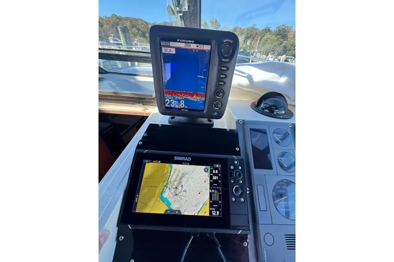 Slide: The Image of 1983 Tiara Yachts 3100 Open helm with steering wheel and navigation equipment. - 10