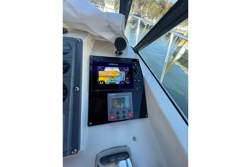 Slide: The Image of Dashboard of a 1983 Tiara Yachts 3100 Open with navigation displays. - 12