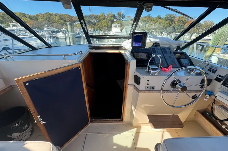 Slide: The Image of 1983 Tiara Yachts 3100 Open helm with steering wheel and navigation equipment. - 15