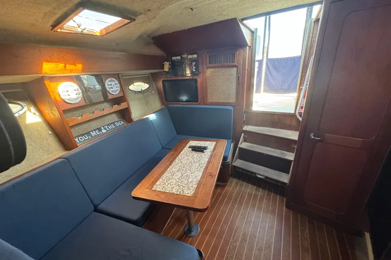 Slide: The Image of 1983 Tiara Yachts 3100 Open interior with kitchenette, sink, and wooden cabinetry. - 21