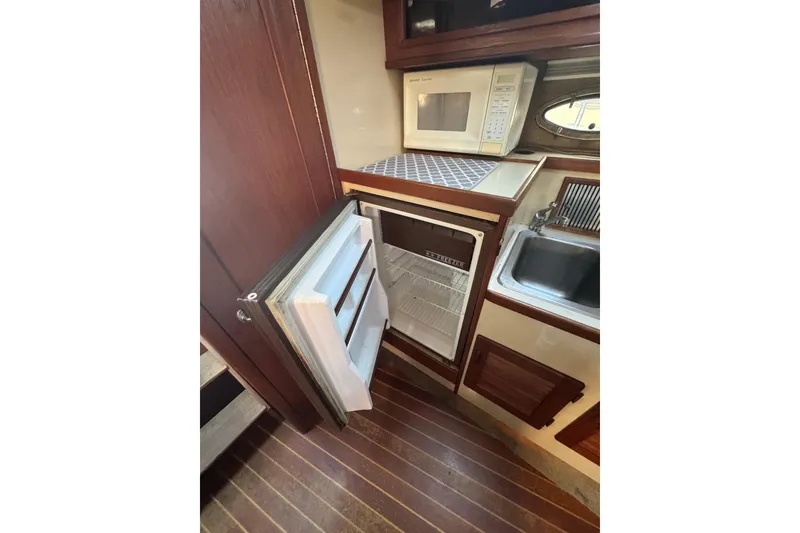 Slide: The Image of Interior of 1983 Tiara Yachts 3100 Open with blue seating and wooden table. - 23