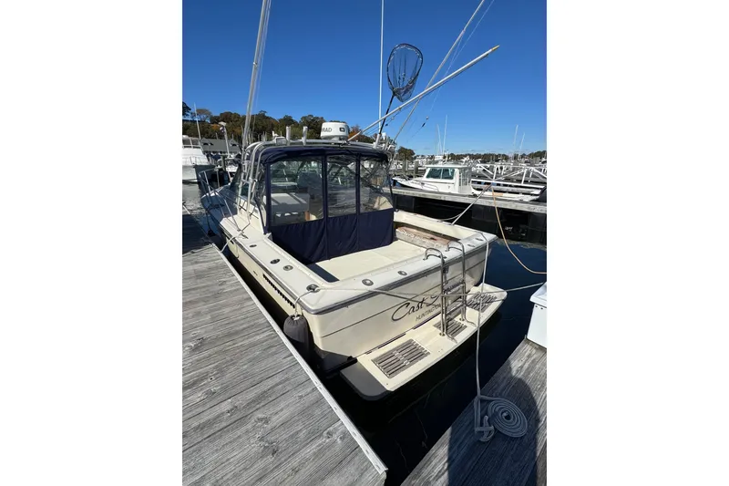 Slide: The Image of 1983 Tiara Yachts 3100 Open docked at a marina, surrounded by other boats. - 3