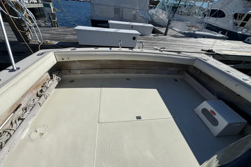 Slide: The Image of 1983 Tiara Yachts 3100 Open docked in a marina under clear blue skies. - 4