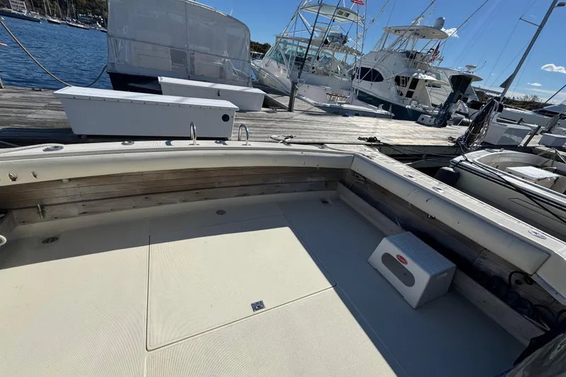 Slide: The Image of 1983 Tiara Yachts 3100 Open docked, featuring fishing gear and a spacious deck. - 5