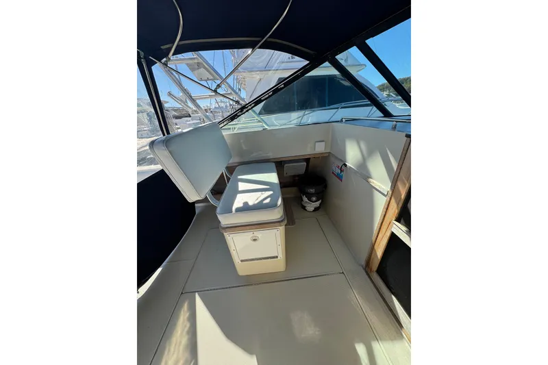 Slide: The Image of 1983 Tiara Yachts 3100 Open at dock, spacious deck, clear sky, marina background. - 7