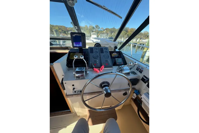 Slide: The Image of 1983 Tiara Yachts 3100 Open docked at a marina under clear blue skies. - 8