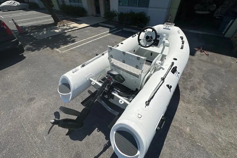 Slide: The Image of Inflatable boat "East Marine NEW 320" with Linergy electric motor, 2026 model, parked outdoors. - 2