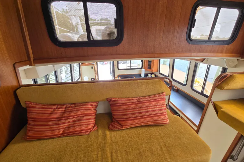 Slide: The Image of Interior of 2001 Nordic Tug 32 with cozy seating and striped cushions. - 8