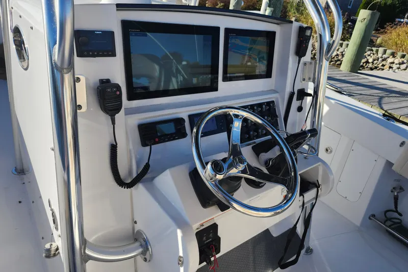 Slide: The Image of Control panel of a 2015 Southport 29 Tournament Edition boat with steering wheel and electronics. - 10