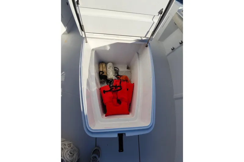 Slide: The Image of Open storage compartment on 2015 Southport 29 Tournament Edition boat with life jacket and gear. - 26