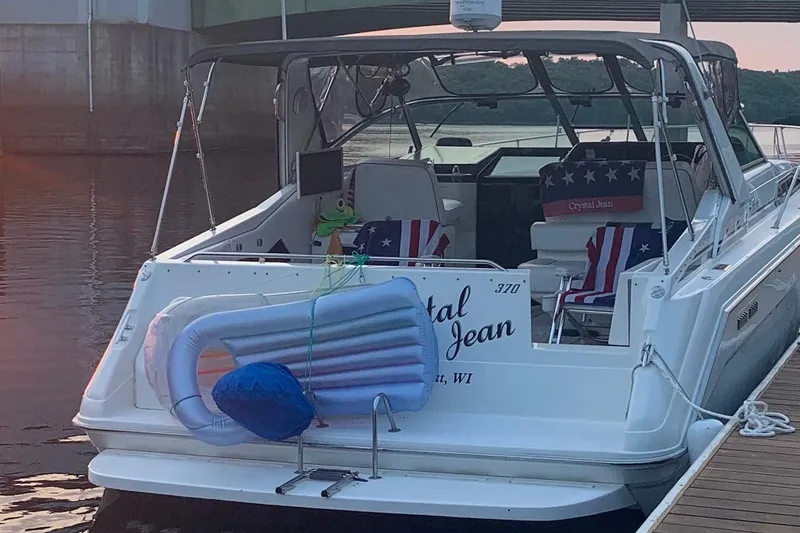 Slide: The Image of 1992 Sea Ray 370 Sundancer docked, featuring patriotic-themed seating and inflatable float. - 12