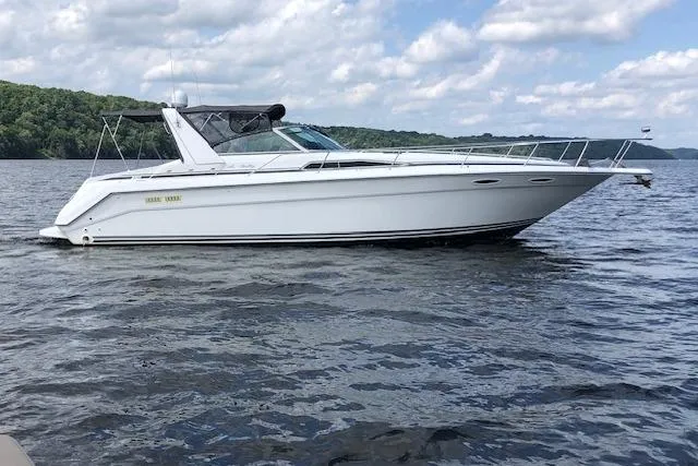 Slide: The Image of 1992 Sea Ray 370 Sundancer boat on a calm lake under a partly cloudy sky. - 13