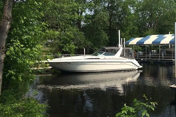 Slide: The Image of 1992 Sea Ray 370 Sundancer yacht docked on a serene lake surrounded by lush greenery. - 7