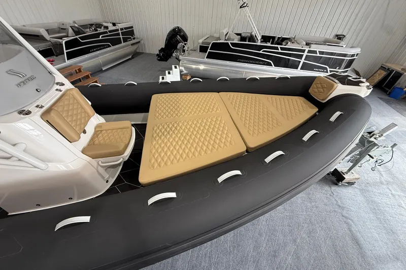 Slide: The Image of 2026 Highfield Sport 800 boat with tan seating, displayed in a showroom. - 13