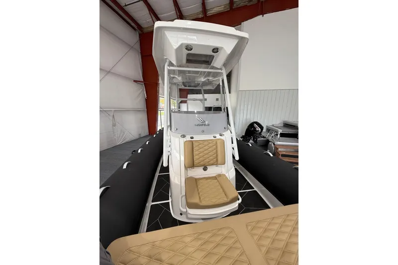 Slide: The Image of 2026 Highfield Sport 800 boat interior with tan seating in a warehouse setting. - 14
