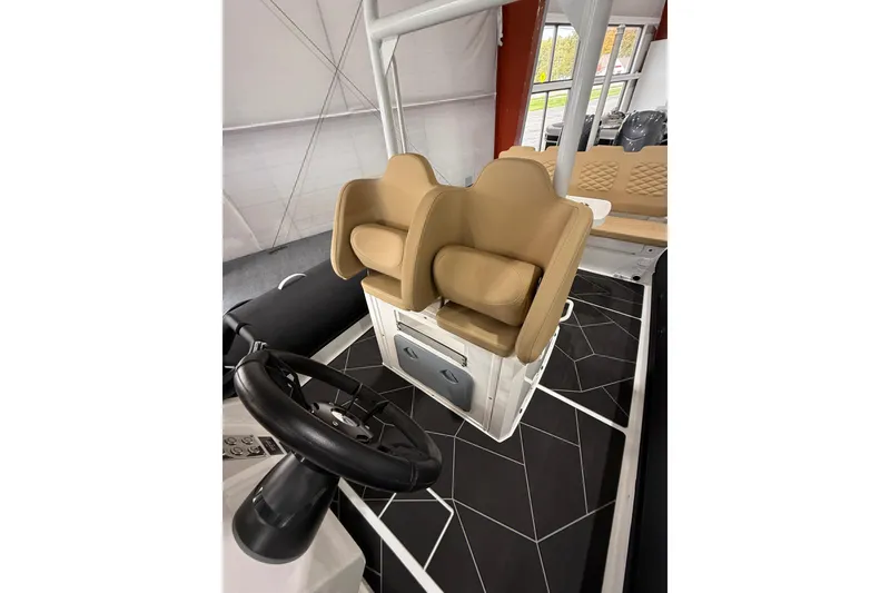 Slide: The Image of 2026 Highfield Sport 800 boat interior with tan seats and black steering wheel. - 17