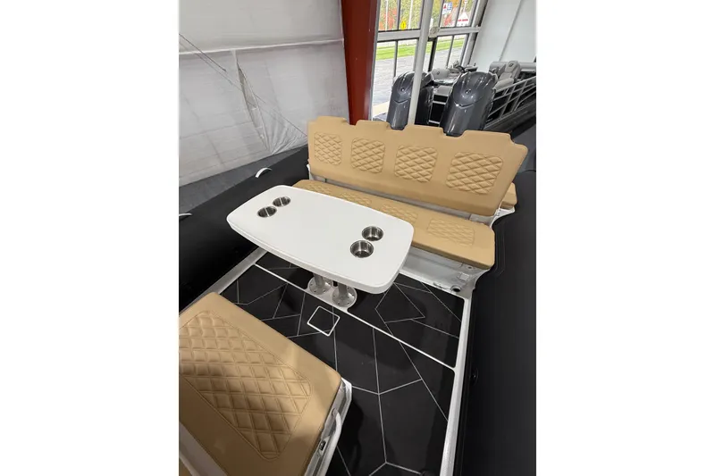 Slide: The Image of 2026 Highfield Sport 800 boat interior with beige quilted seating and a white table. - 23