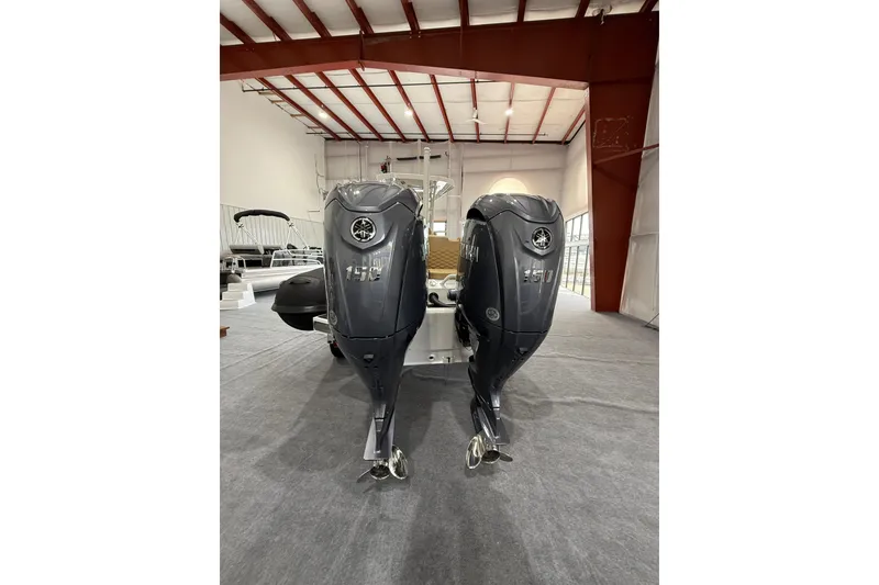 Slide: The Image of 2026 Highfield Sport 800 boat with dual 150 horsepower outboard engines in a showroom. - 7