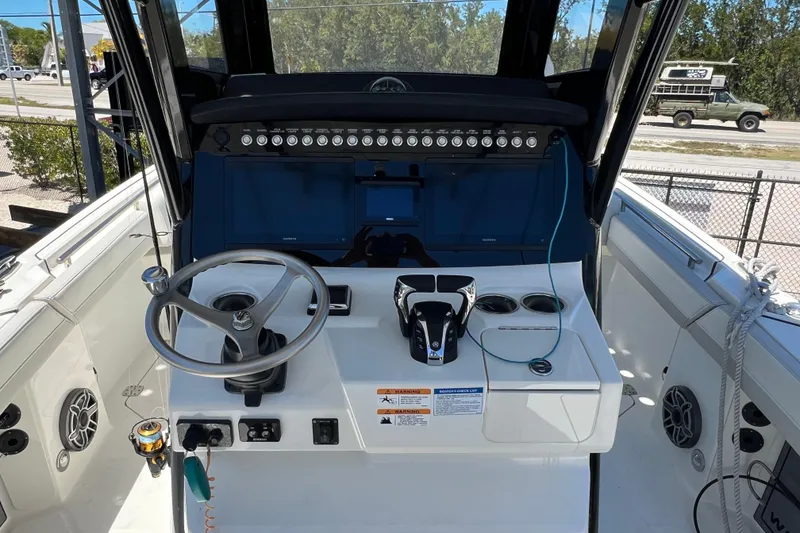 Slide: The Image of 2024 World Cat 260 CC-X boat helm with steering wheel and control panel. - 7